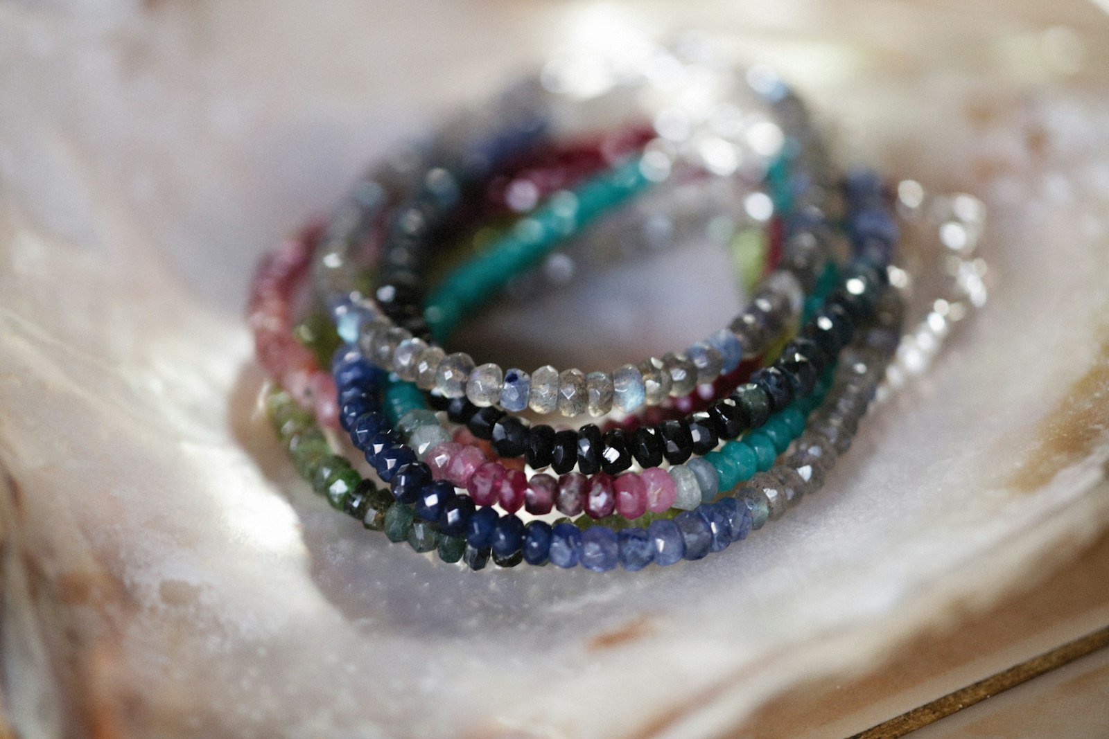 Beaded bracelet stack resting in an oyster shell